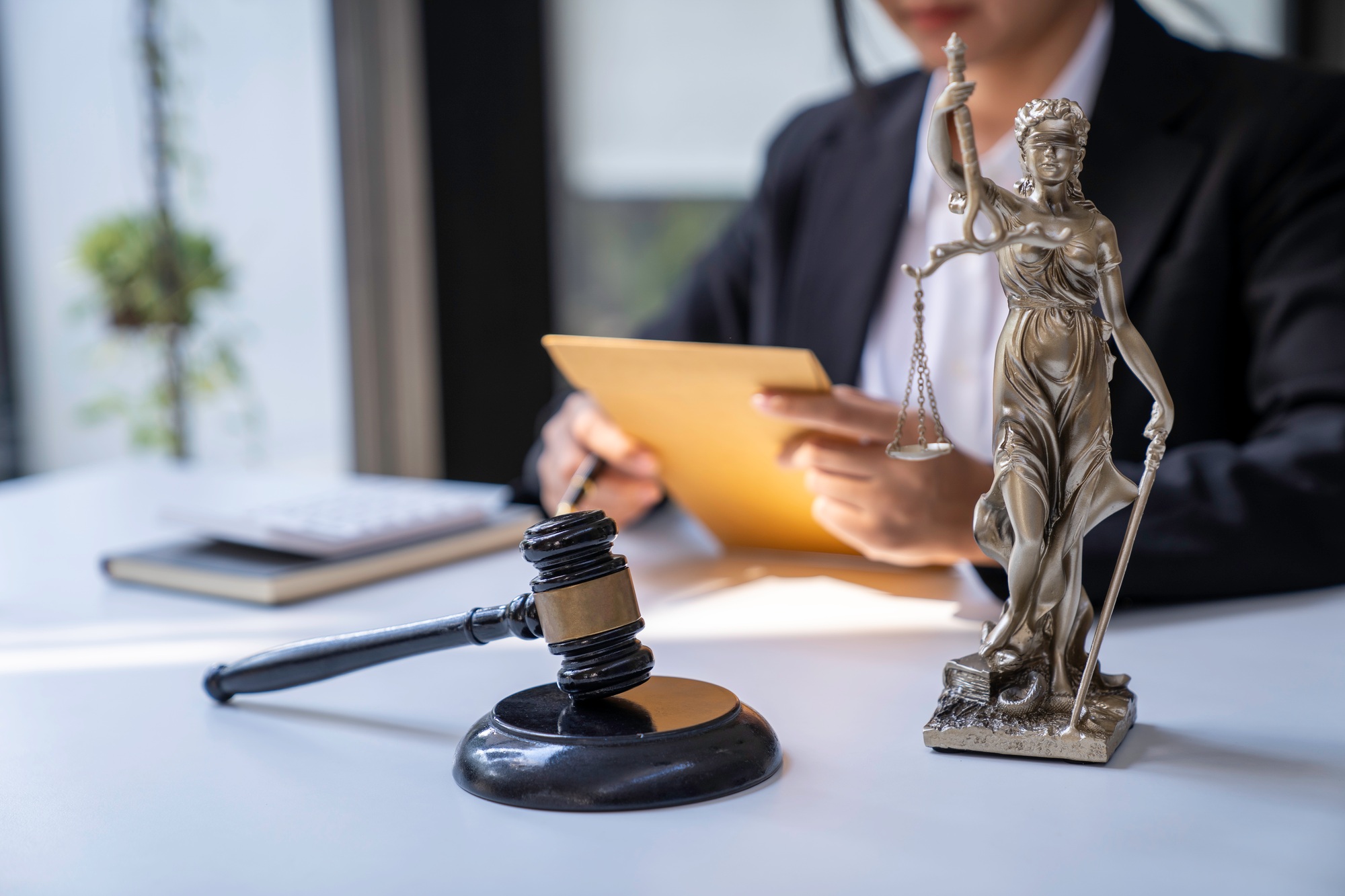 A judge takes a hammer with a lawyer for justice. A businesswoman in a suit or a lawyer works on doc